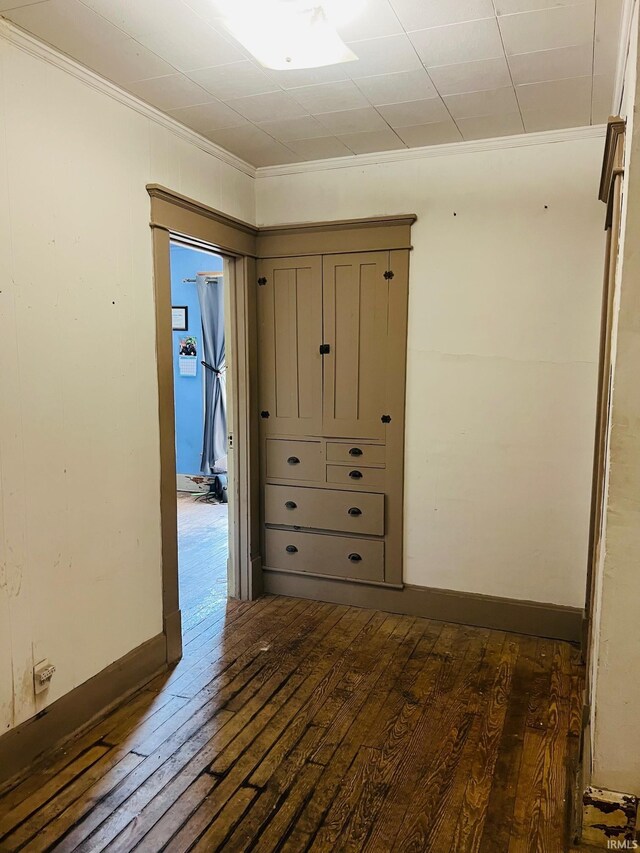 interior space featuring crown molding, dark wood-style floors, and baseboards