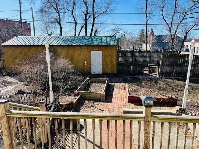 view of yard featuring an outbuilding, a vegetable garden, and fence