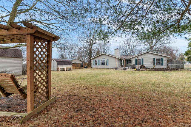 view of yard with an outbuilding, a fenced backyard, and a shed