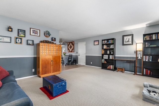 carpeted living area with baseboards