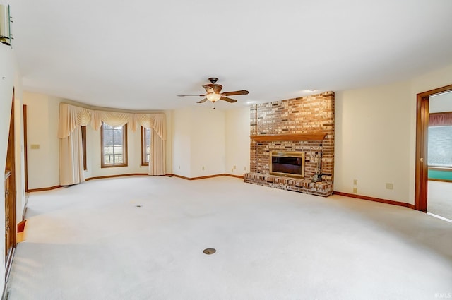 unfurnished living room featuring ceiling fan, a brick fireplace, baseboards, and carpet floors