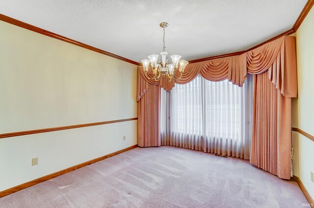 unfurnished room featuring light carpet, a notable chandelier, crown molding, and baseboards