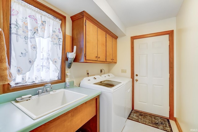 washroom with a sink, cabinet space, and washing machine and clothes dryer