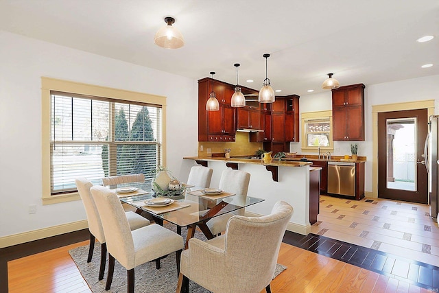 dining room with recessed lighting, baseboards, and light wood finished floors