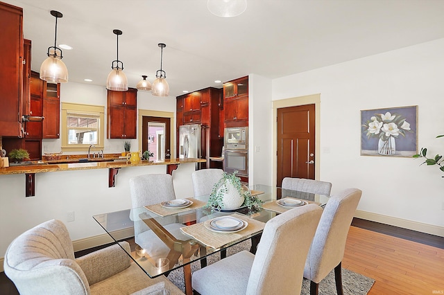 dining area with recessed lighting, baseboards, and hardwood / wood-style flooring