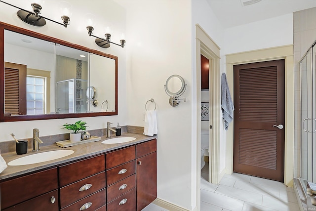 full bathroom with a sink, toilet, a stall shower, and double vanity