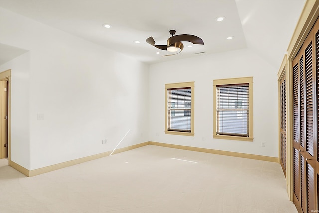 spare room featuring light carpet, recessed lighting, baseboards, and ceiling fan