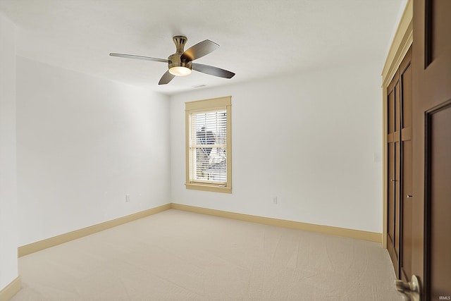 unfurnished bedroom featuring light carpet, ceiling fan, a closet, and baseboards