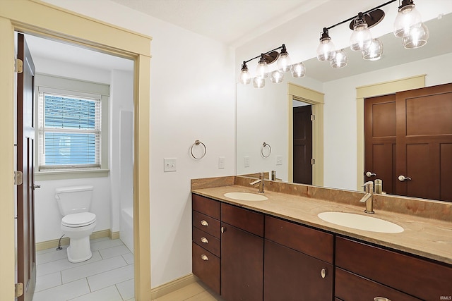 bathroom with double vanity, tile patterned flooring, toilet, and a sink