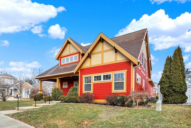 view of front facade featuring a front yard, central AC unit, and a shingled roof