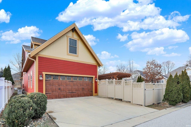 view of property exterior with a gate, fence, and driveway