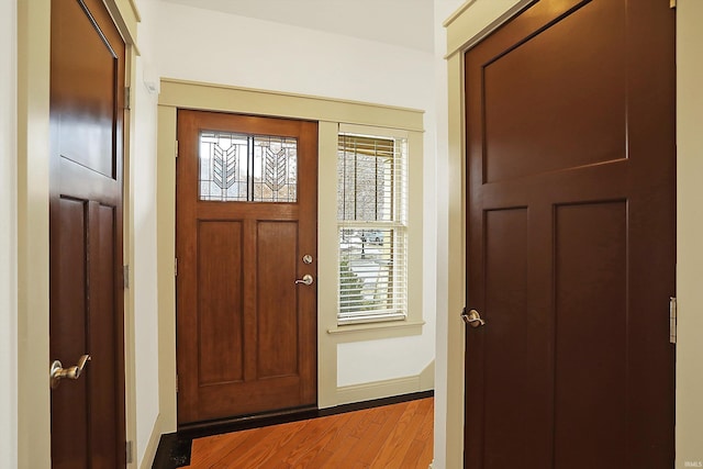 foyer featuring baseboards and wood finished floors