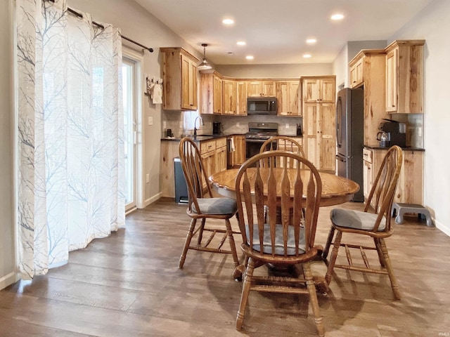 dining space featuring recessed lighting, wood finished floors, and baseboards