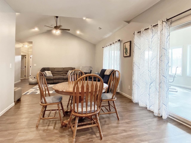 dining room with vaulted ceiling, wood finished floors, baseboards, and a wealth of natural light