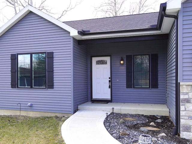 property entrance with a porch and a shingled roof