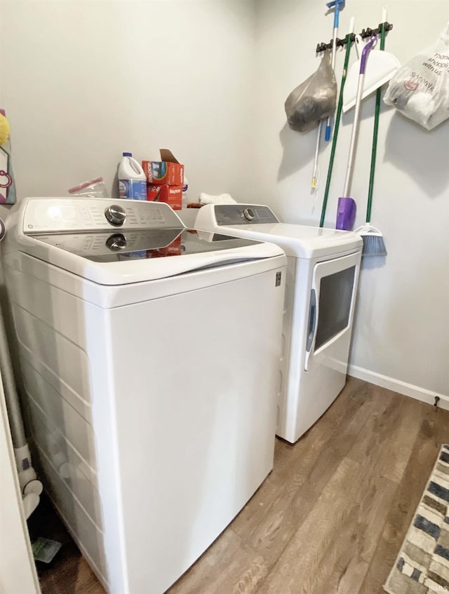 laundry room with washer and dryer, laundry area, light wood-style flooring, and baseboards