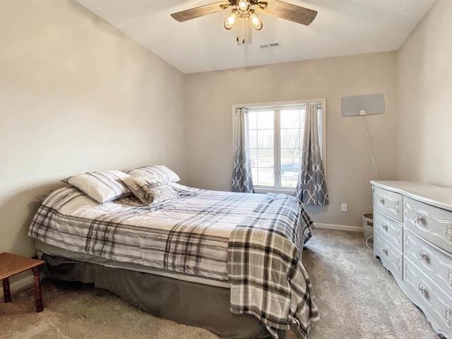 bedroom with visible vents, baseboards, light colored carpet, and ceiling fan