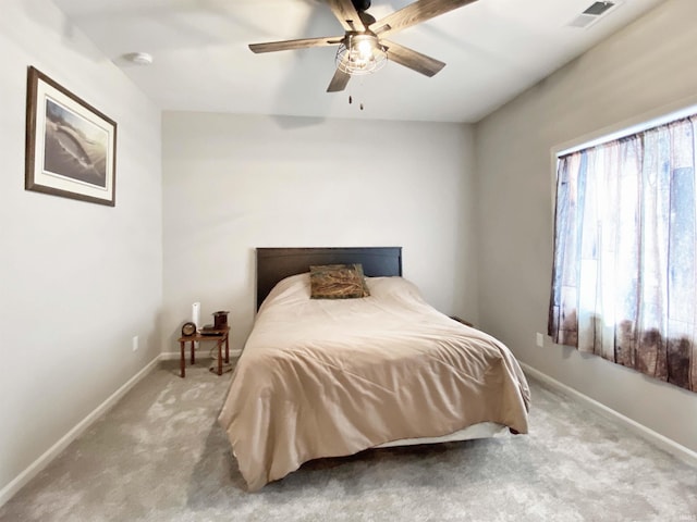 bedroom featuring ceiling fan, baseboards, visible vents, and light carpet