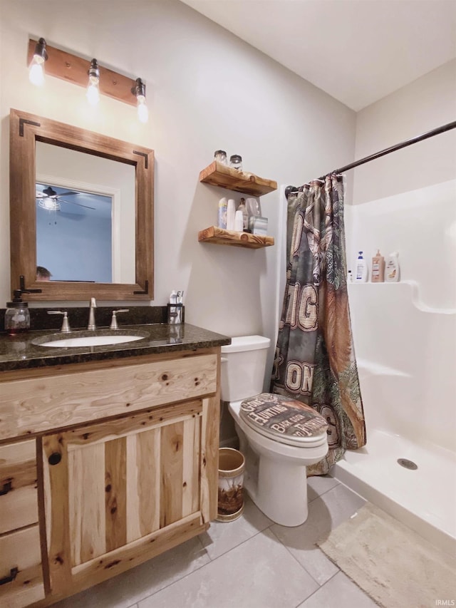 bathroom with tile patterned flooring, a shower stall, toilet, and vanity