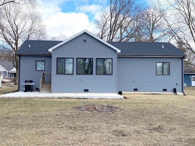 rear view of property with crawl space, a lawn, a patio, and roof with shingles