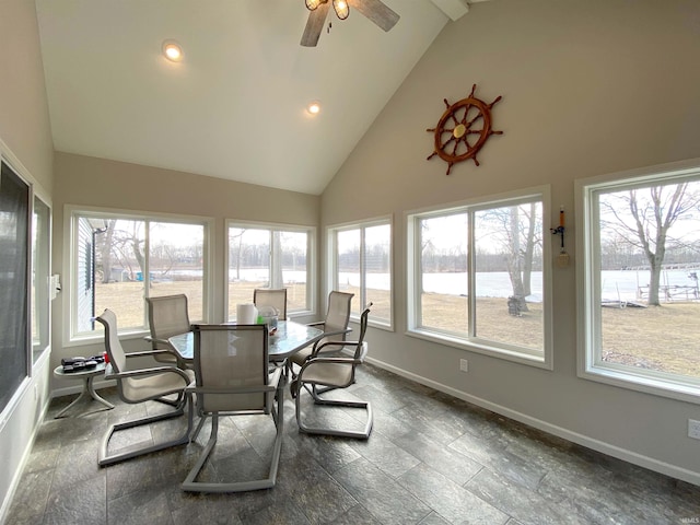 sunroom featuring a ceiling fan, lofted ceiling, and a water view