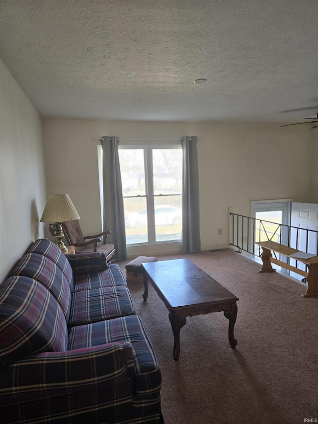 carpeted living room with a ceiling fan, a wealth of natural light, and a textured ceiling