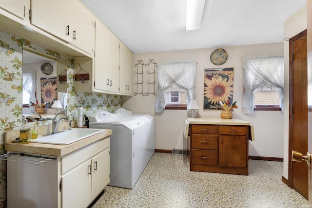 laundry room featuring wallpapered walls, baseboards, washer and clothes dryer, cabinet space, and a sink