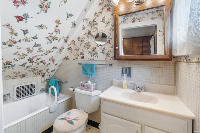 bathroom featuring toilet, wallpapered walls, vanity, and tiled tub