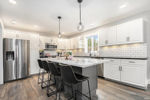 kitchen with white cabinets, stainless steel appliances, and wood finished floors