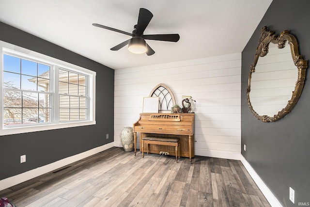 interior space featuring visible vents, ceiling fan, baseboards, and wood finished floors