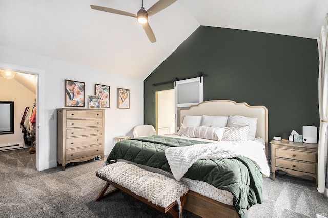 carpeted bedroom featuring ceiling fan, a barn door, a walk in closet, and vaulted ceiling