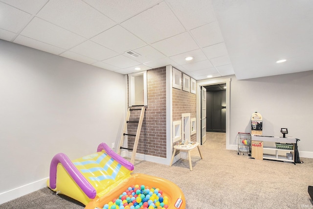 recreation room with a drop ceiling, baseboards, visible vents, and carpet flooring