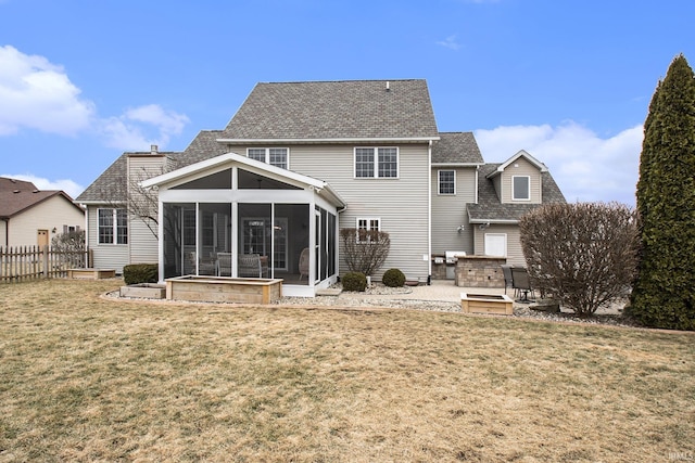 back of house with fence, a chimney, a yard, a sunroom, and a patio area