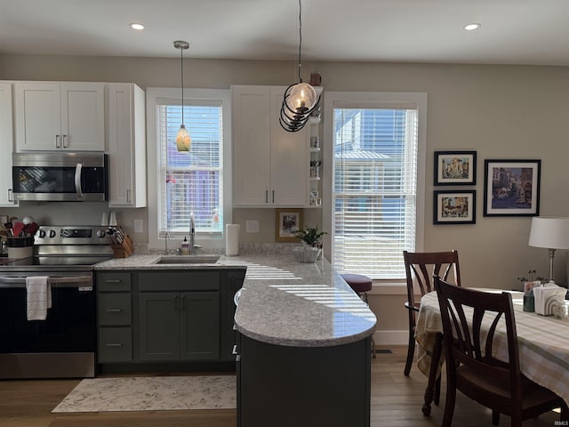 kitchen featuring a sink, light countertops, a peninsula, and stainless steel appliances