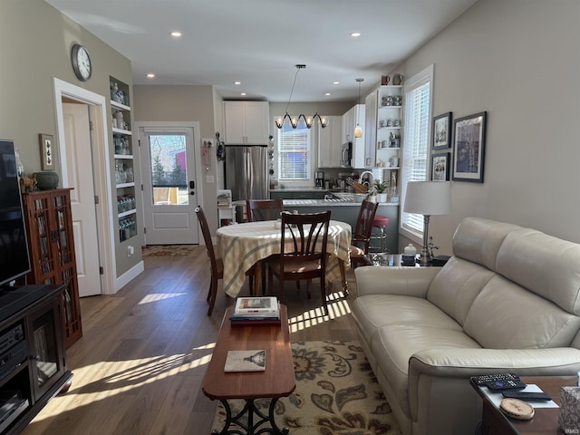 living area featuring a notable chandelier, recessed lighting, and wood finished floors