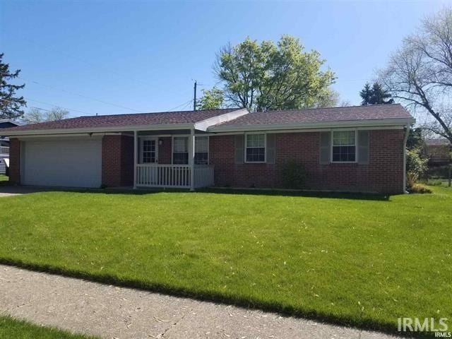 ranch-style house with brick siding, an attached garage, driveway, and a front yard