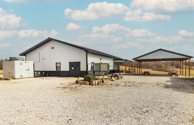 6889 N County Road 775 E, Grandview, IN 47615 - back of house featuring a carport, an outdoor structure, and central AC