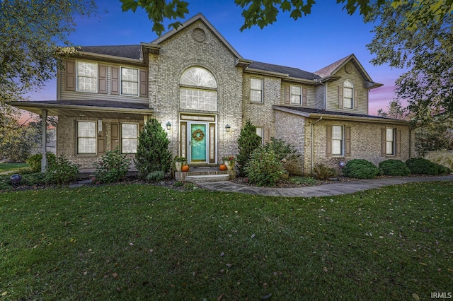 view of front of home with a front yard and brick siding