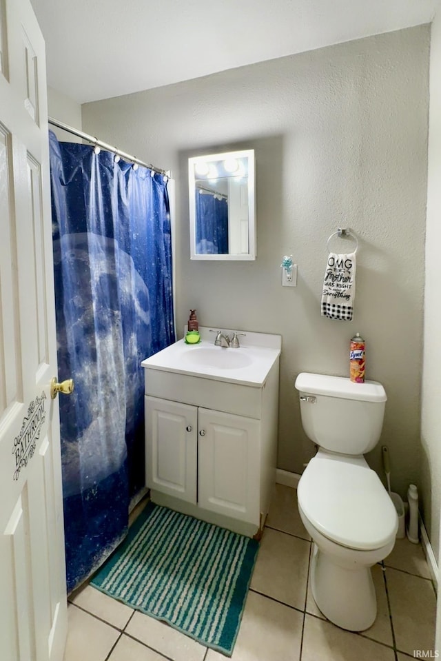 bathroom with tile patterned floors, baseboards, toilet, and vanity