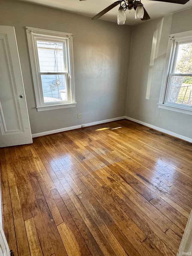 spare room with ceiling fan, baseboards, and hardwood / wood-style floors