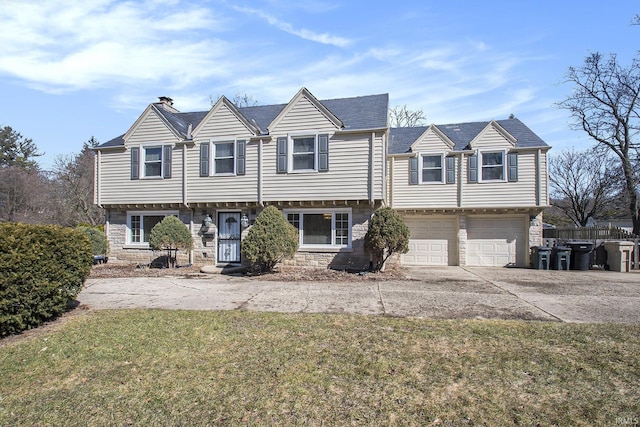 view of front of home with a front lawn, fence, a garage, stone siding, and driveway