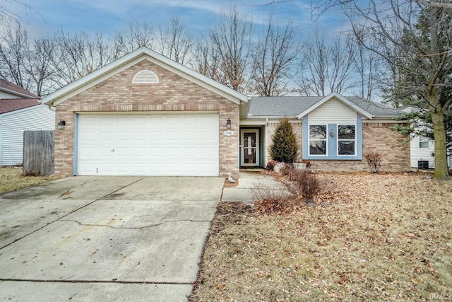 single story home featuring central AC unit, driveway, roof with shingles, an attached garage, and brick siding