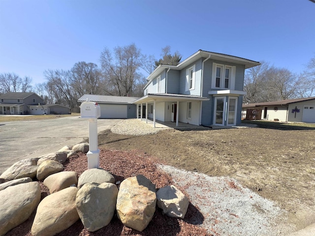 view of front facade featuring an outbuilding, an attached garage, and driveway