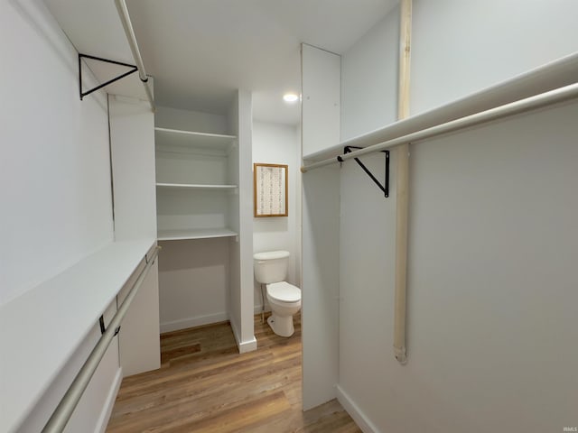 bathroom featuring toilet, wood finished floors, and baseboards