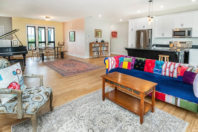 living area with recessed lighting, baseboards, and light wood finished floors