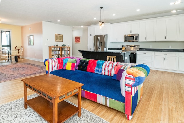 living area with recessed lighting, baseboards, and light wood-style floors