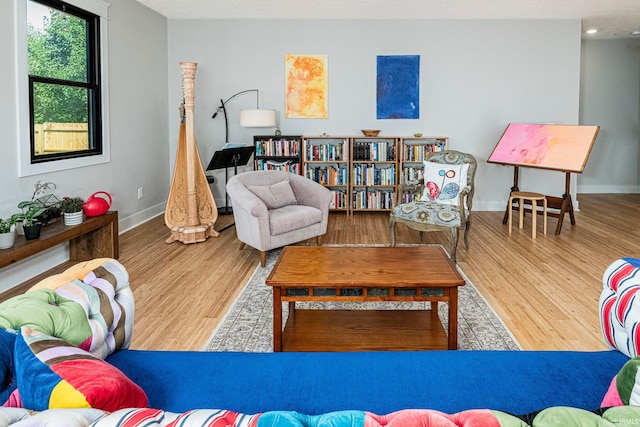 living area with baseboards and wood finished floors