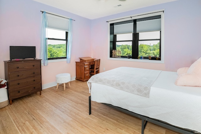 bedroom with light wood-type flooring, baseboards, and visible vents