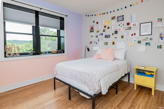 bedroom with light wood-style floors and baseboards