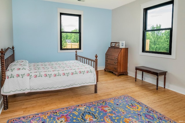 bedroom with visible vents, baseboards, and wood finished floors